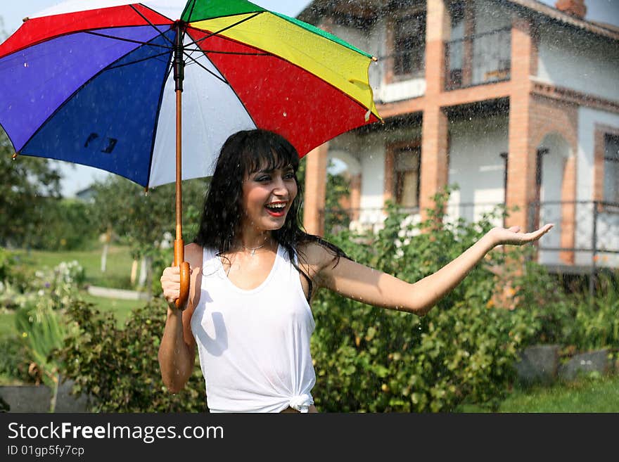 Girl under umbrella in summer rain