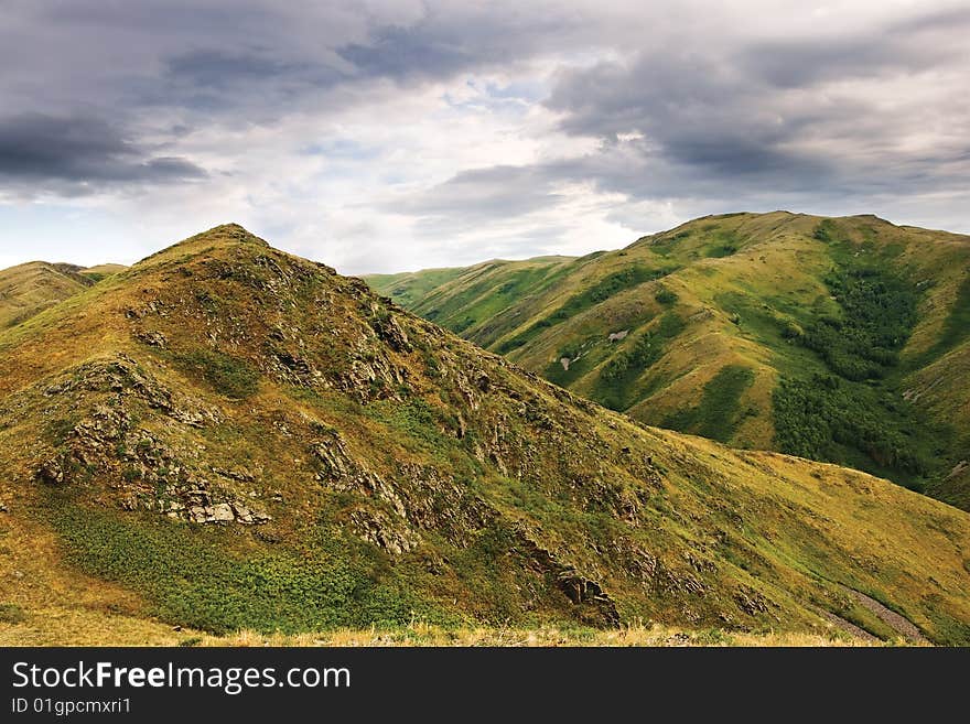 Mountain with rocks under cloudy sky