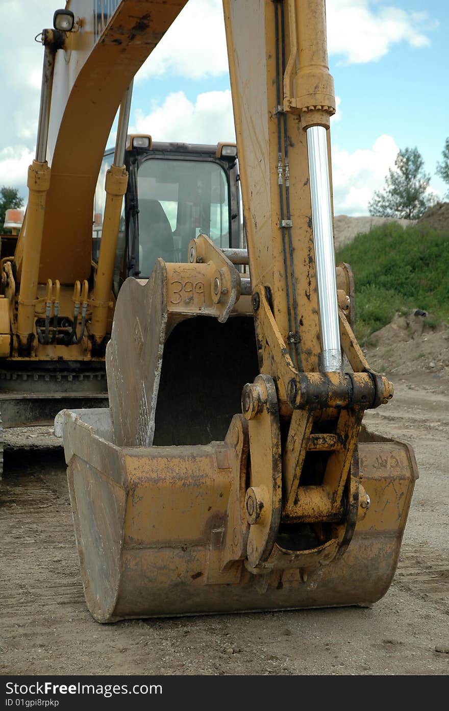 Yellow excavator bucket on ground waiting for driver. Yellow excavator bucket on ground waiting for driver