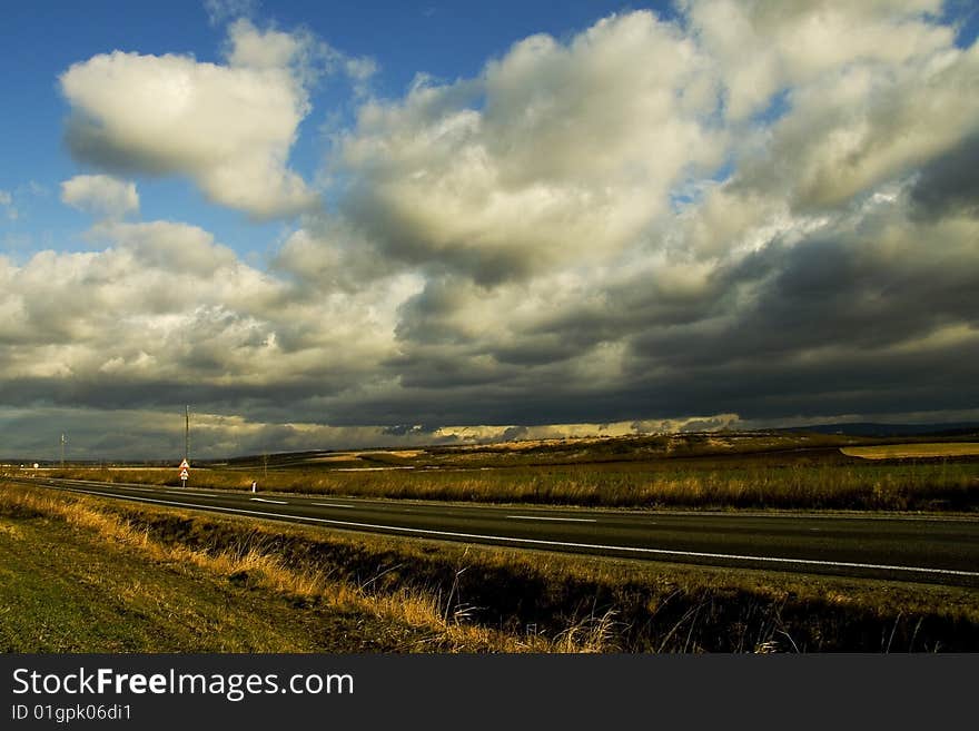 Image of a an empty road and blue sky and clouds. Image of a an empty road and blue sky and clouds