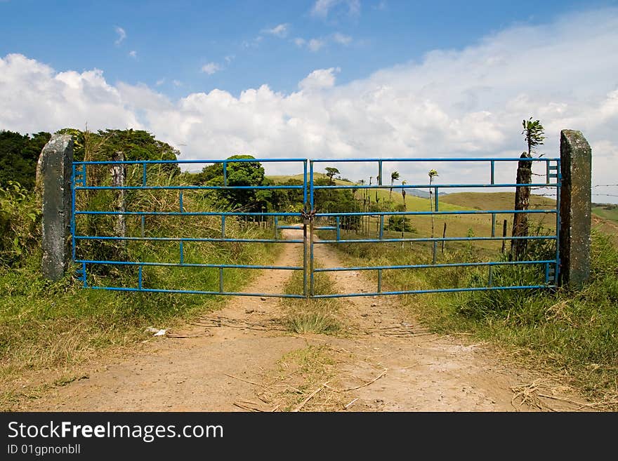 Closed blue metal gates on a country road in Costa RIca. Closed blue metal gates on a country road in Costa RIca