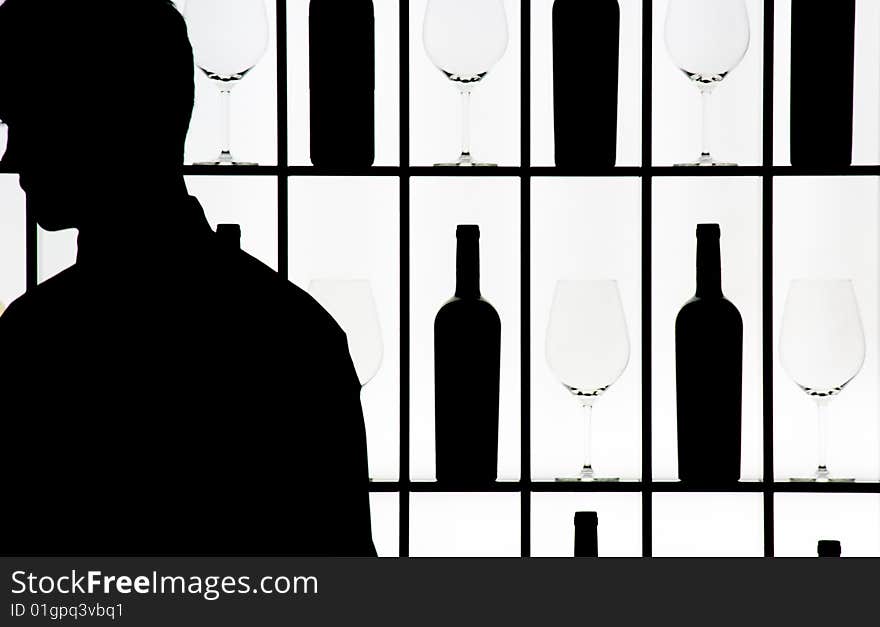 Silouette of a waitress against bottle and glasses on a luminous wall. Silouette of a waitress against bottle and glasses on a luminous wall