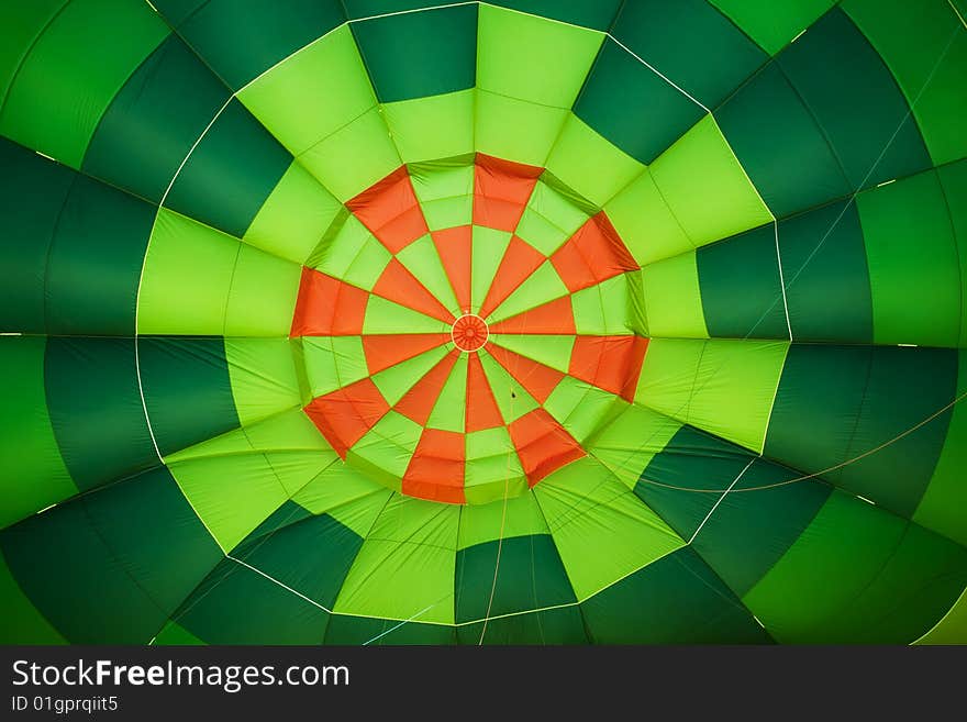 Colorful balloon interior creating green and orange background.