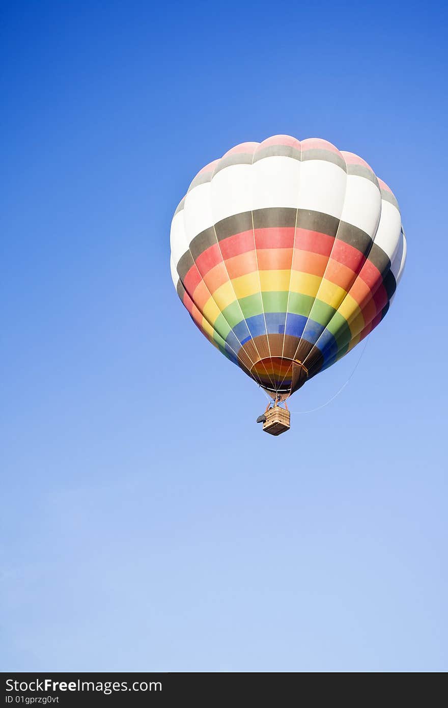 Lone balloon in a blue sky as background.