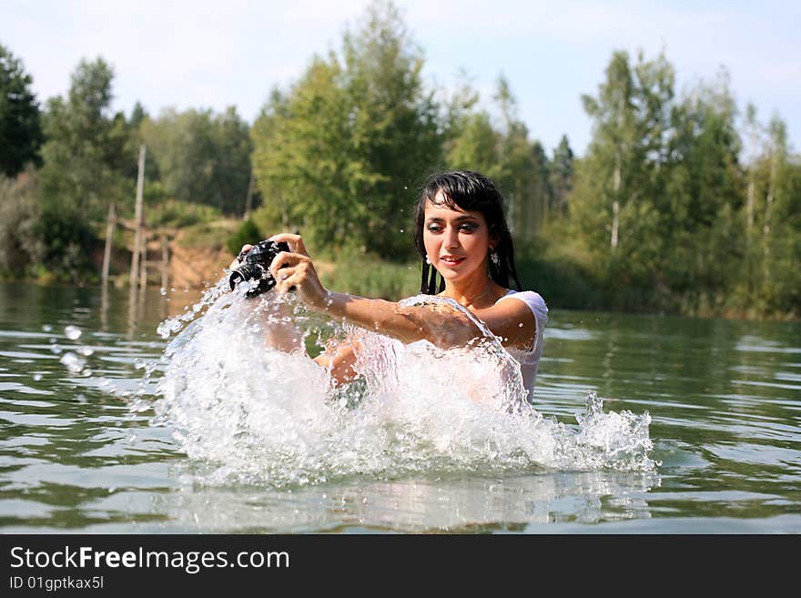 Lovely girl photographer in water in summertime