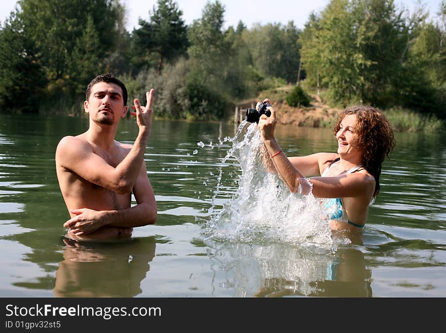 Girl shooting boy in water with waterproof camera. Girl shooting boy in water with waterproof camera