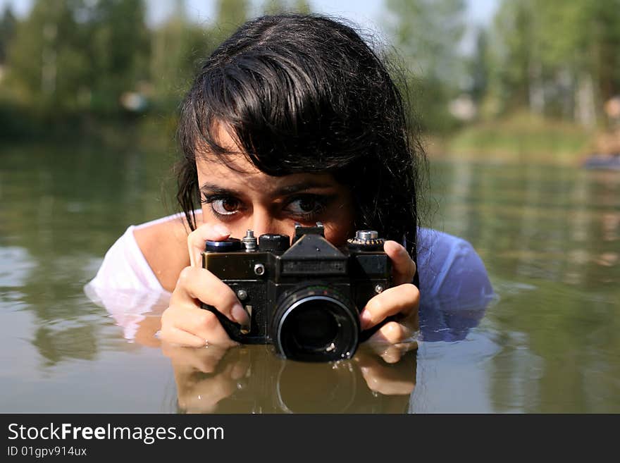 Lovely girl shooting photo in water