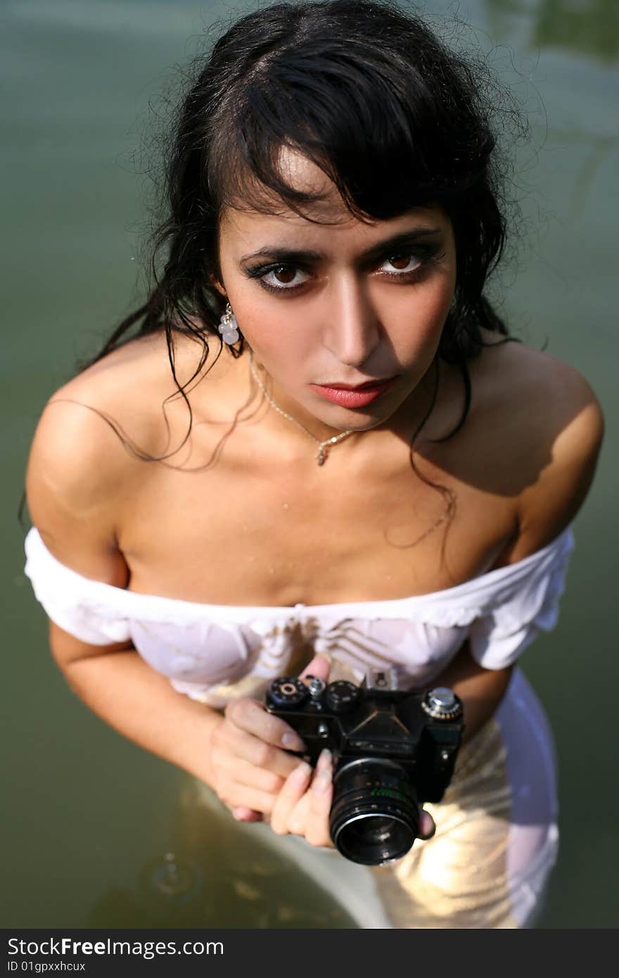 Lovely girl photographer in water with camera