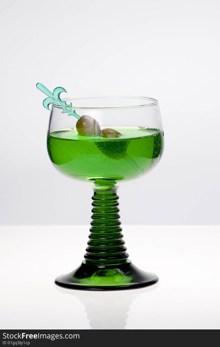 Green cocktail glass on a clean white background