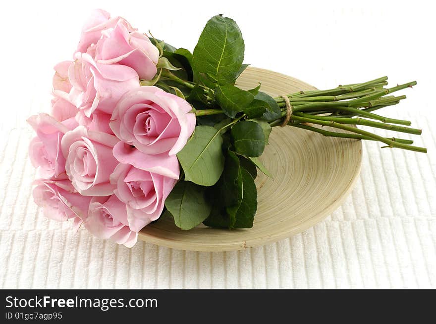 Bouquet of pink roses in wooden bowl