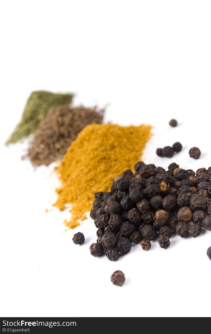 Haps of various ground spices on white background