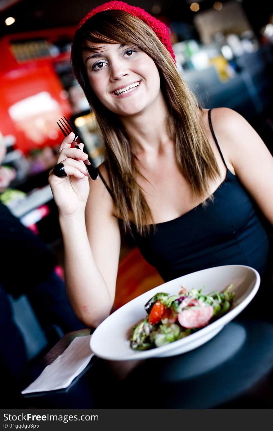 A beautiful young woman having lucnh in a cafe