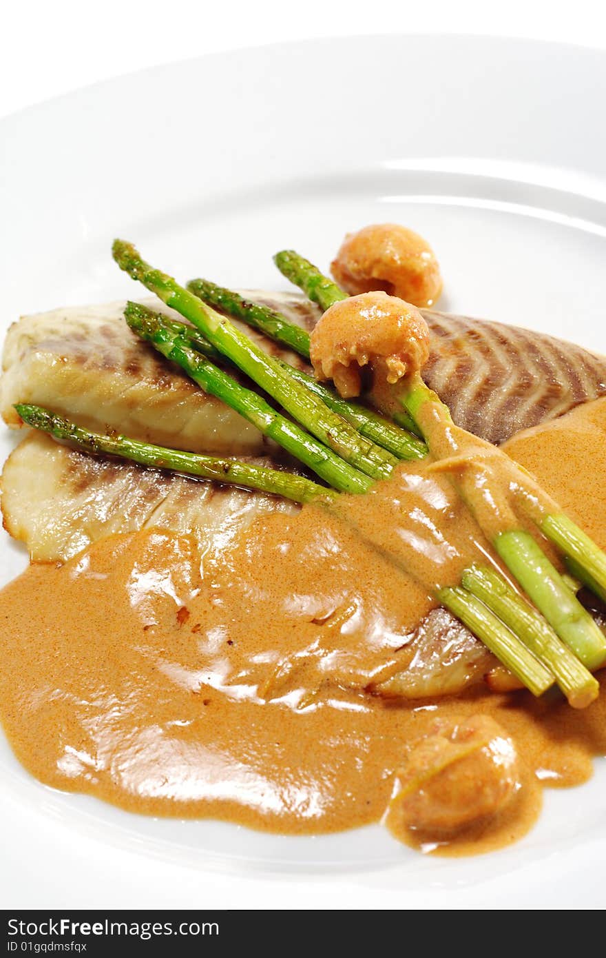 Sea Bass Fillet with Tomato Sauce and Fresh Asparagus. Isolated on White Background