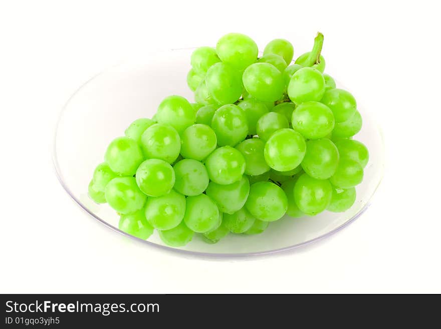 Green grapes in bowl on white background