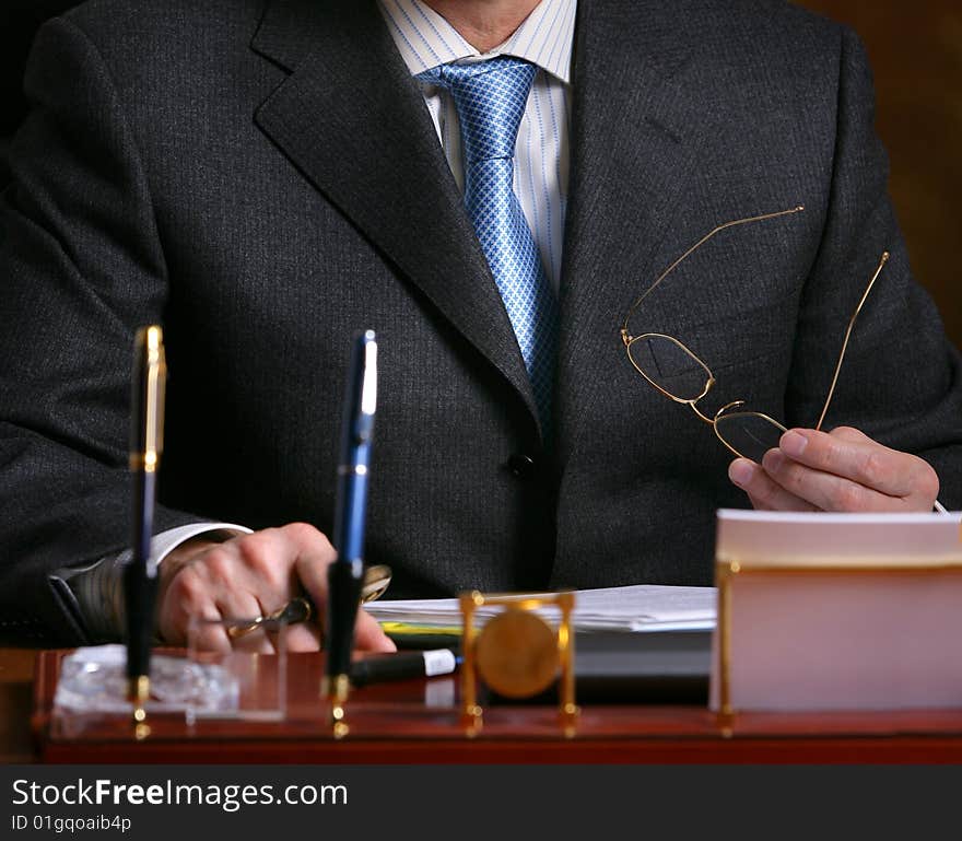 Hand of a man in suit holding glasses. Hand of a man in suit holding glasses