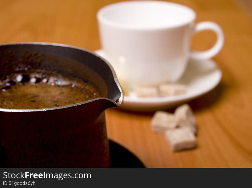 Coffee-maker, cup and sugar on wooden table