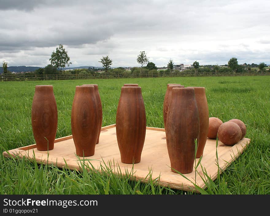 A set of wooden skittles are set up outdoors, ready to play. A set of wooden skittles are set up outdoors, ready to play.