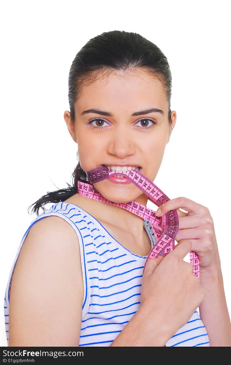 Young woman standing with measuring tape around neck and between teeth