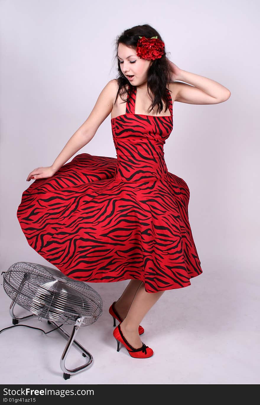 Pin-up girl standing near a ventilator in studio