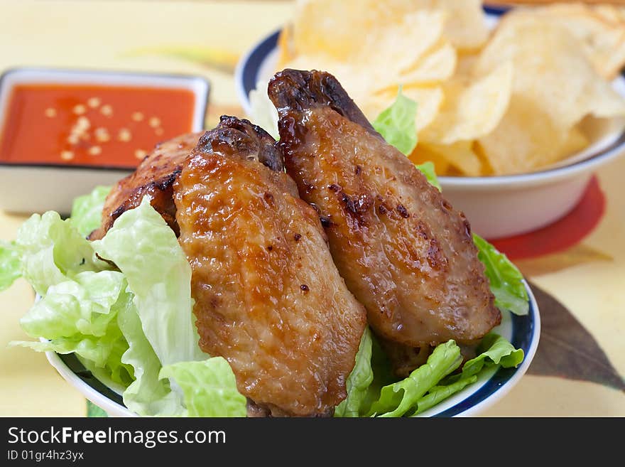 Grilled chicken wings with hot pepper sauce and salad