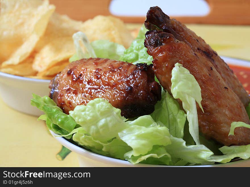 Grilled chicken wings with hot pepper sauce and salad