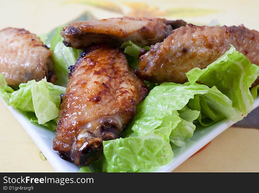 Grilled chicken wings with hot pepper sauce and salad