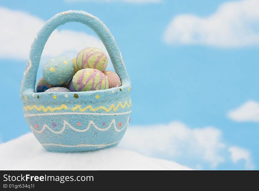 A basket of colourful Easter eggs on blue sky background, Easter