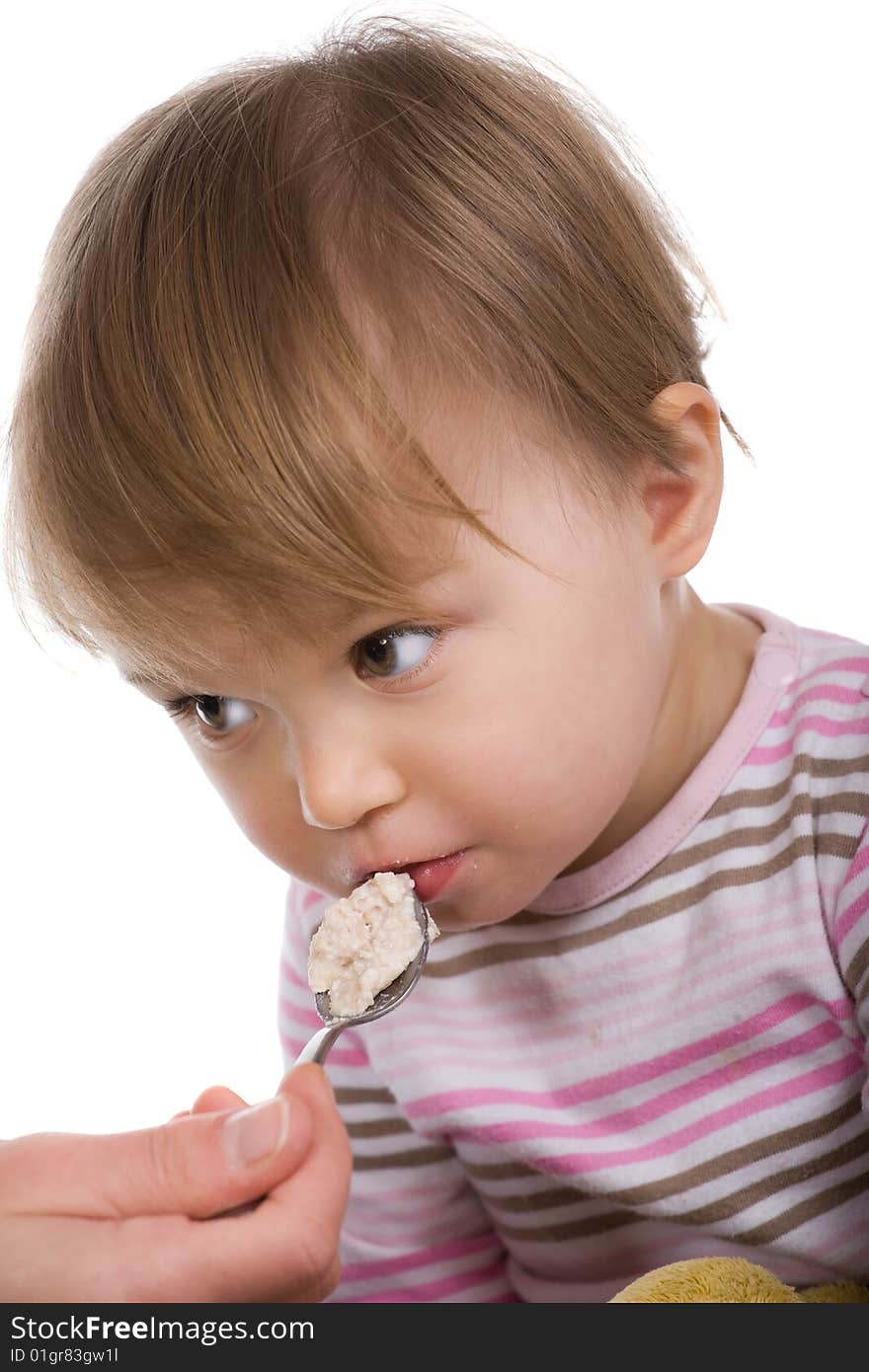 Happy baby girl eating isolated