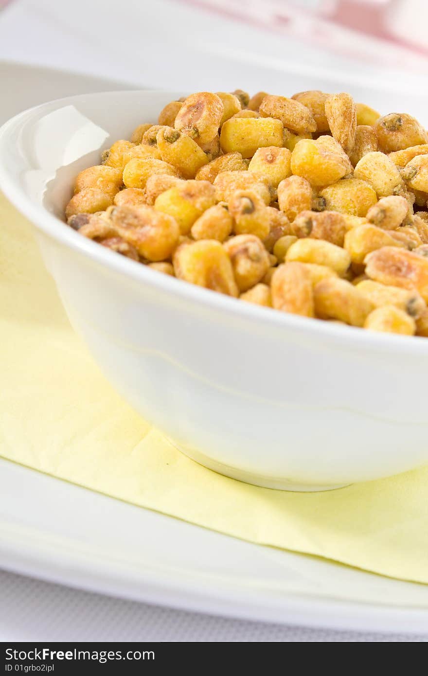 Salted fried corn in a white bowl. Salted fried corn in a white bowl