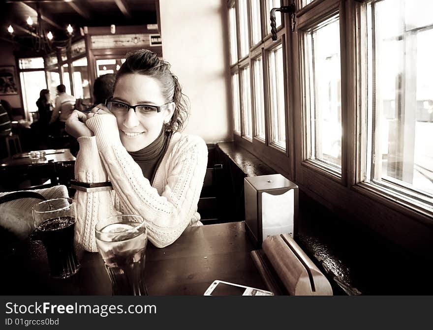 Young cheerful woman drinking in a pub. Young cheerful woman drinking in a pub