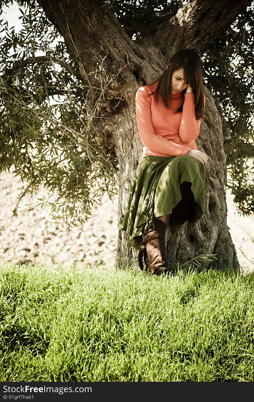 Young thoughtful woman on tree .