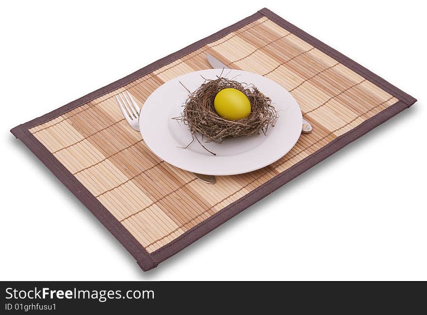 Gold egg in a nest served on a plate