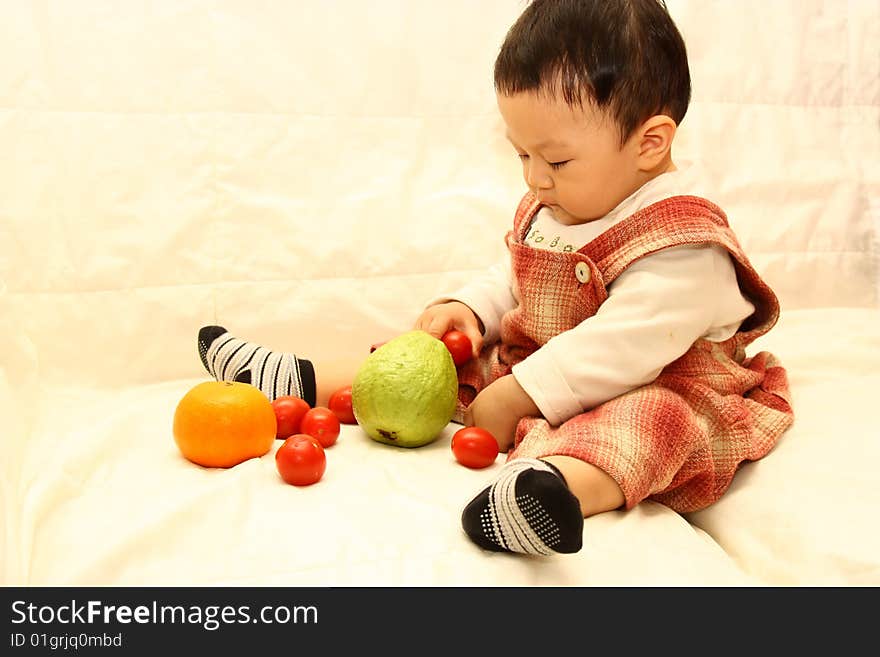 Child with fruits(Tomato,orange and guava)