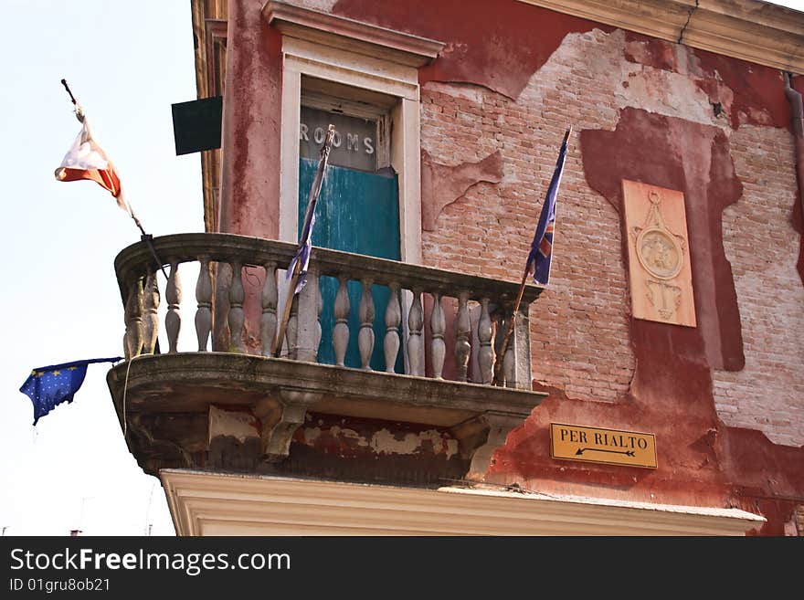 An original shot of a venecian building, on the wall an indication for rialto, the most famous bridge in venecia, on the windows and indication of room (in english). An original shot of a venecian building, on the wall an indication for rialto, the most famous bridge in venecia, on the windows and indication of room (in english)