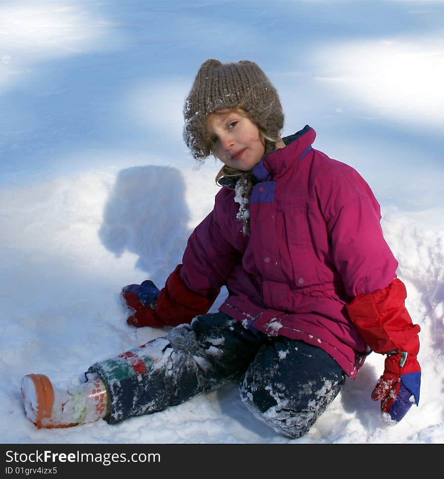 A Little Girl Sits Playing In The Snow