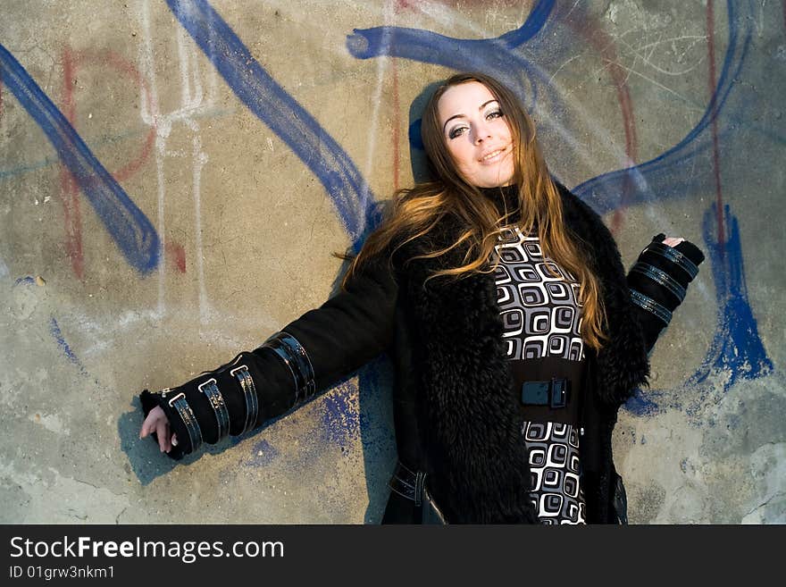 Stock photo: an image of a nice woman standing at the wall