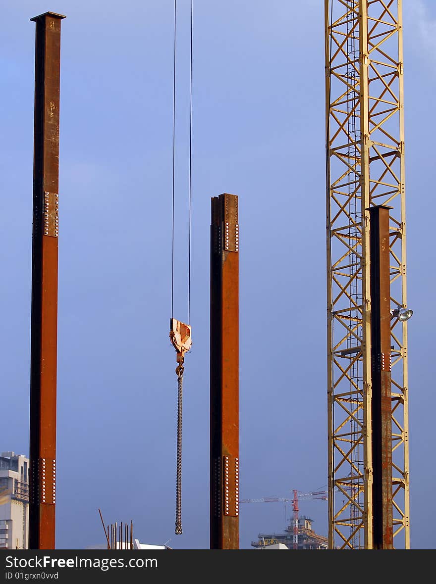 Metal poles and crane with sky as background. Metal poles and crane with sky as background