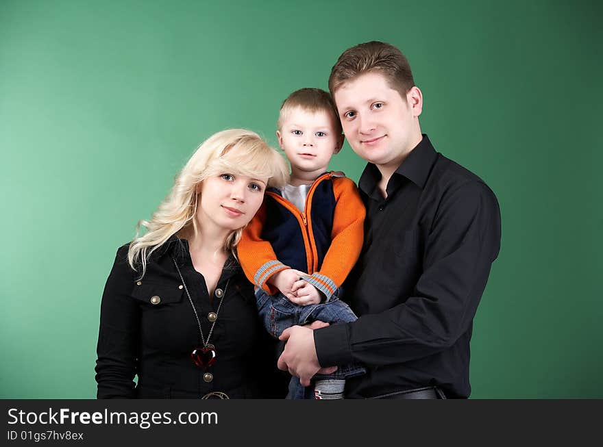 Happy family with baby on green background. Happy family with baby on green background