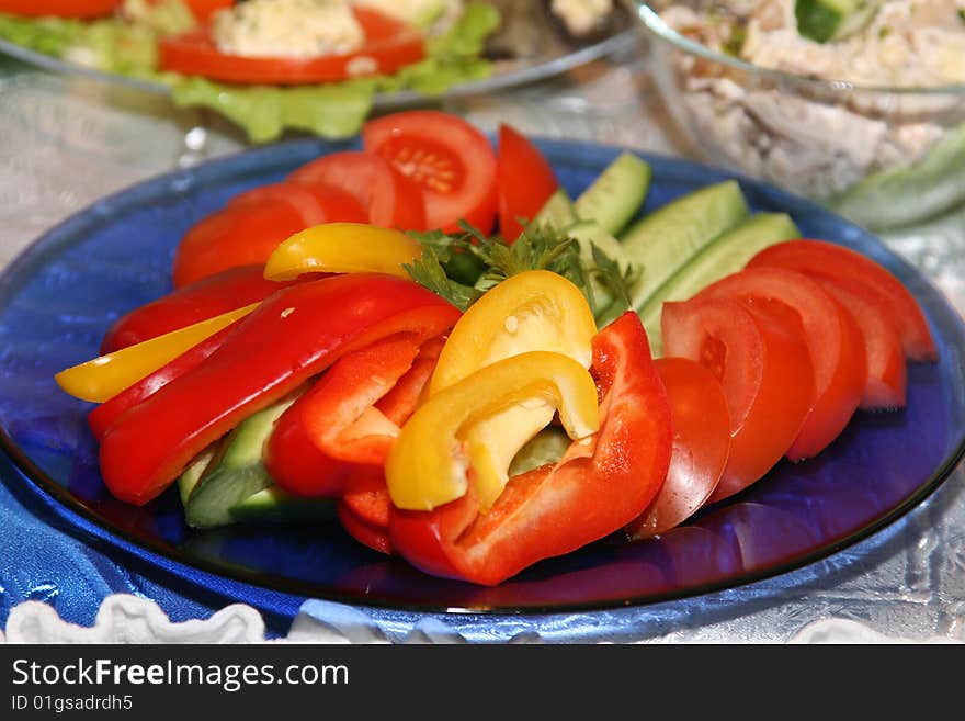 Salad on a dish from tomatoes, pepper and cucumbers