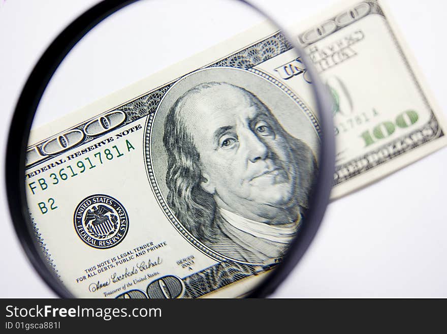 Isolated hundred dollars under magnifier