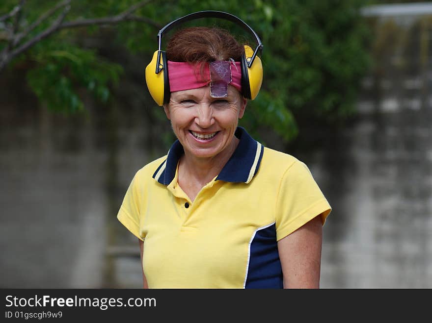 Smiling female competitor at shooting range preparing to shoot