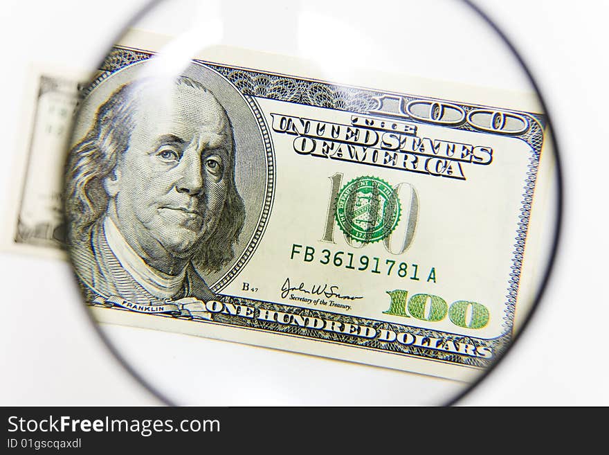 Isolated hundred american dollars under magnifier. Isolated hundred american dollars under magnifier