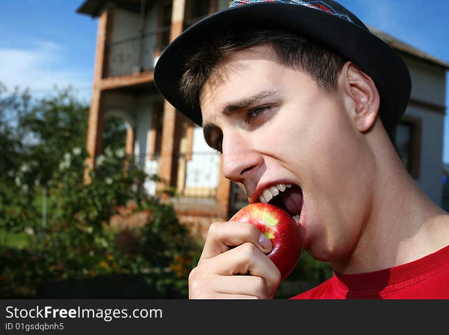 Young happy man with apple beside him new house