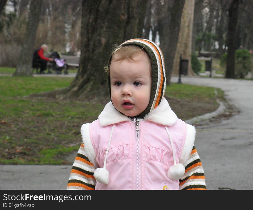 Little girl walking trough the park. Little girl walking trough the park.