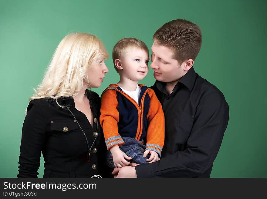 Happy family with baby on green background. Happy family with baby on green background