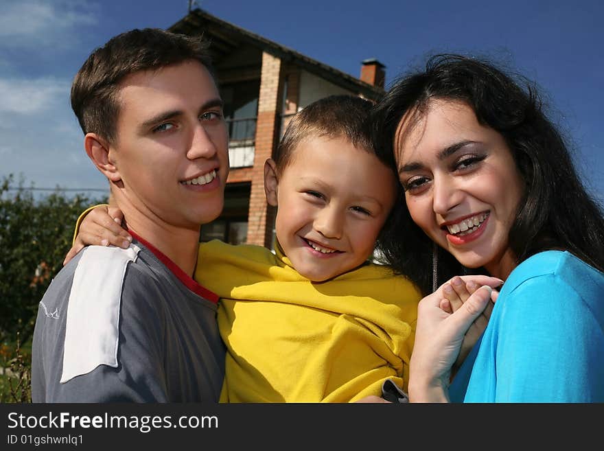 Young happy family beside their new house