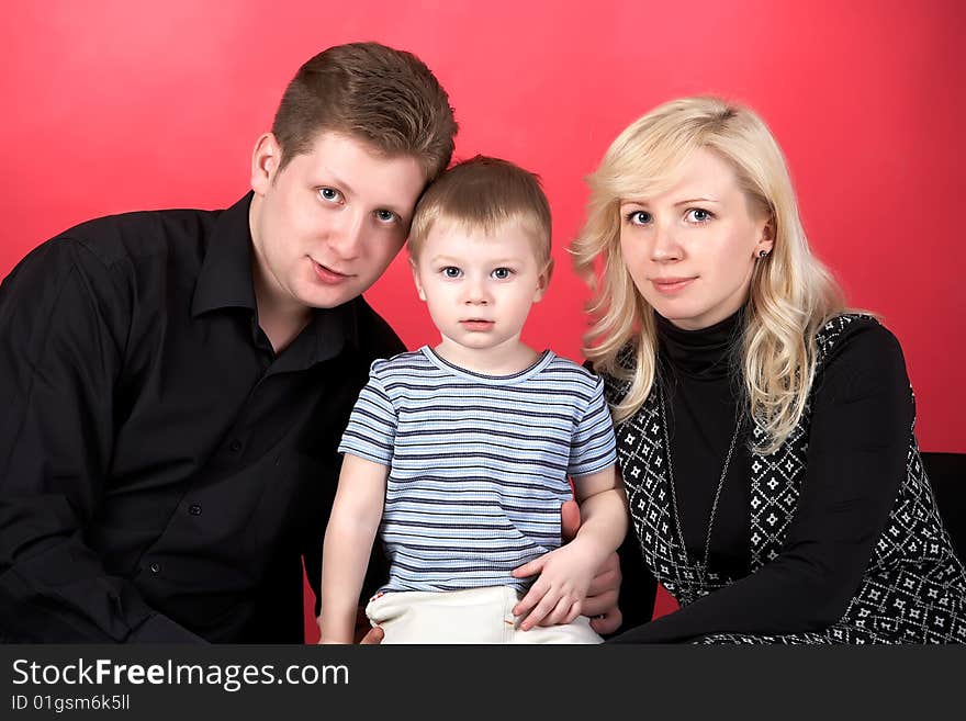 Happy family with baby on red background. Happy family with baby on red background