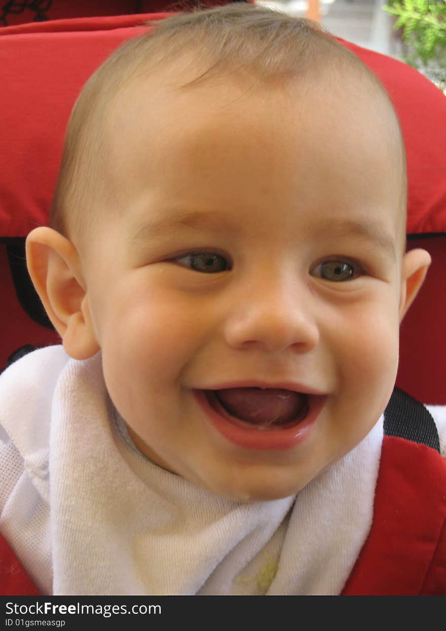 A happy little boy laughing with the camera.