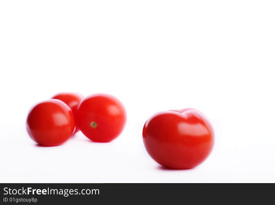 Four red tomatos one in front