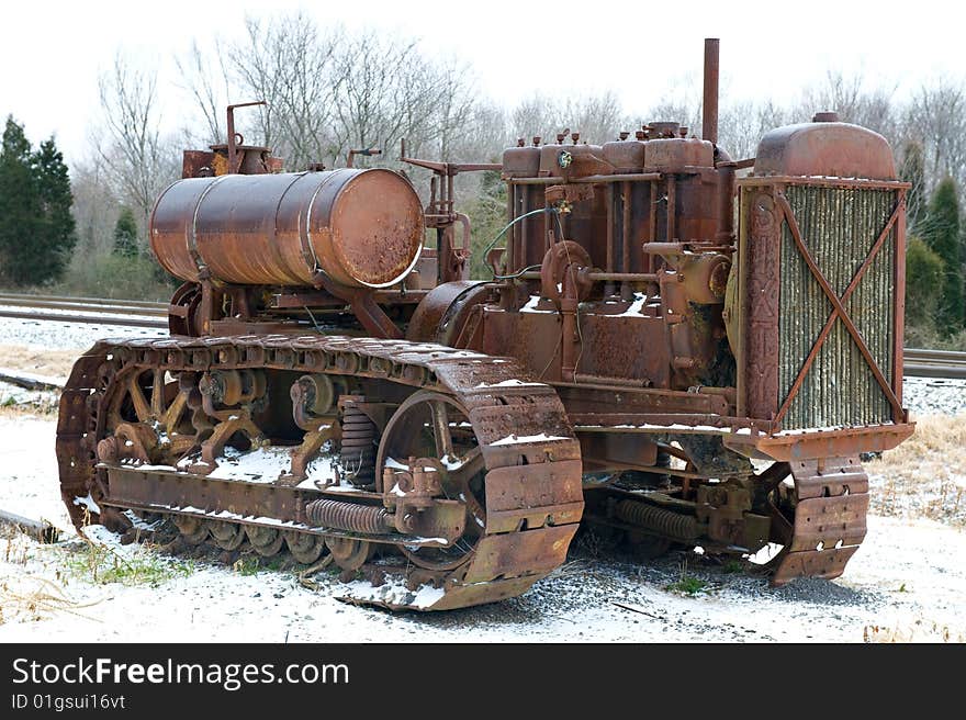 Old rusty tractor sitting in light layer of snow. Old rusty tractor sitting in light layer of snow